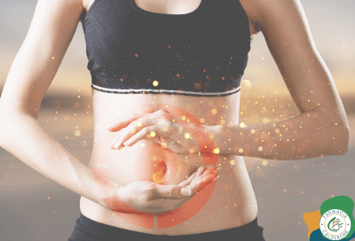 Donna in abbigliamento sportivo che poggia le mani sul ventre, con effetti grafici luminosi e simbolo di bersaglio sull’addome, a rappresentare l’importanza dell’equilibrio intestinale e della salute digestiva.