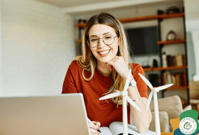 Donna sorridente al computer, pronta a ripartire con energia e motivazione dopo il ritorno alla routine.